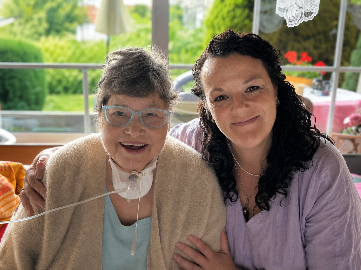 Anne Hühnlein lächelt gemeinsam mit einer Patientin in die Kamera